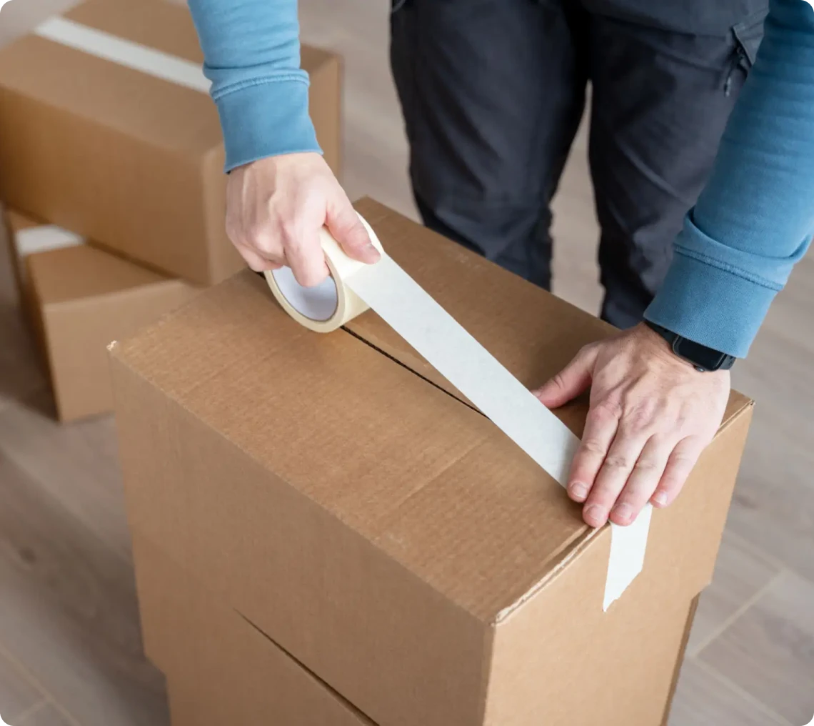 Hands securing box with packing tape